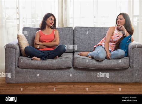 two girls sitting on brown couch porn|Two brunette girls sharing a long cock on the couch